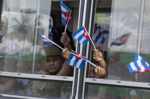People sit in a bus heading to see the ashes of Cuba's leader Fidel Castro in Bartolome Maso, on the foothills of Sierra Maestra, Cuba, Friday, Dec. 2, 2016. Castro's ashes are on a four-day journey across Cuba from Havana to their final resting place in the eastern city of Santiago. (AP Photo/Ricardo Mazalan)
